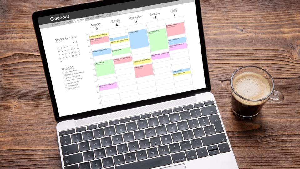 Laptop with calendar app on screen filled with different weekly appointments, meetings and tasks