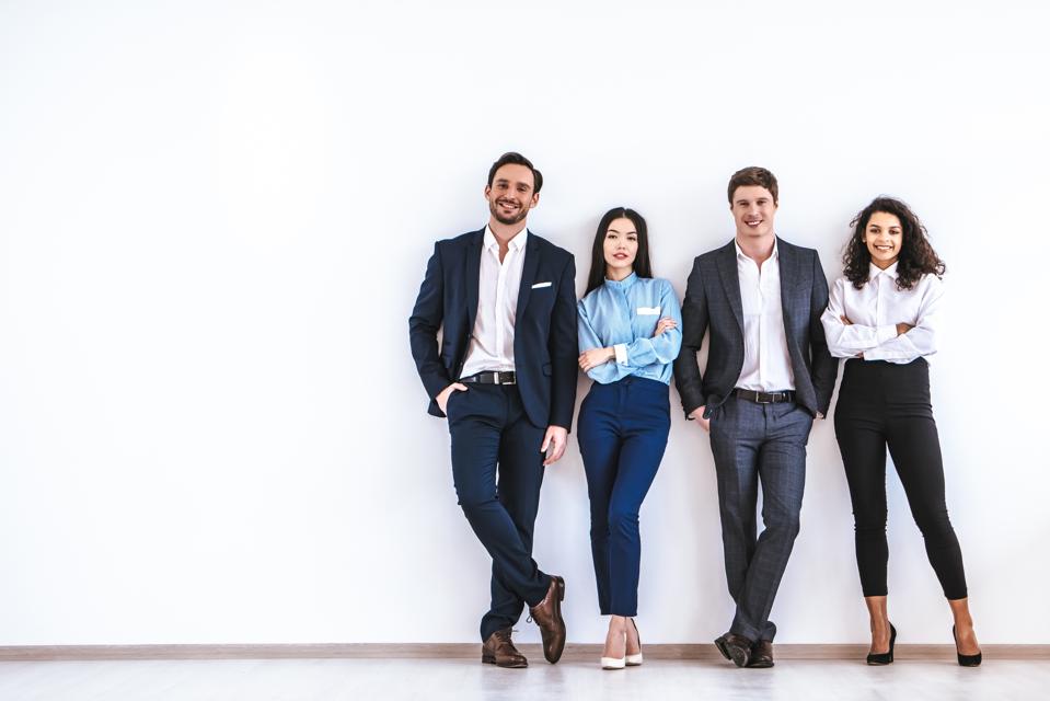 Los empresarios parados en el fondo de la pared blanca muestran la importancia de la experiencia Gen Z.
