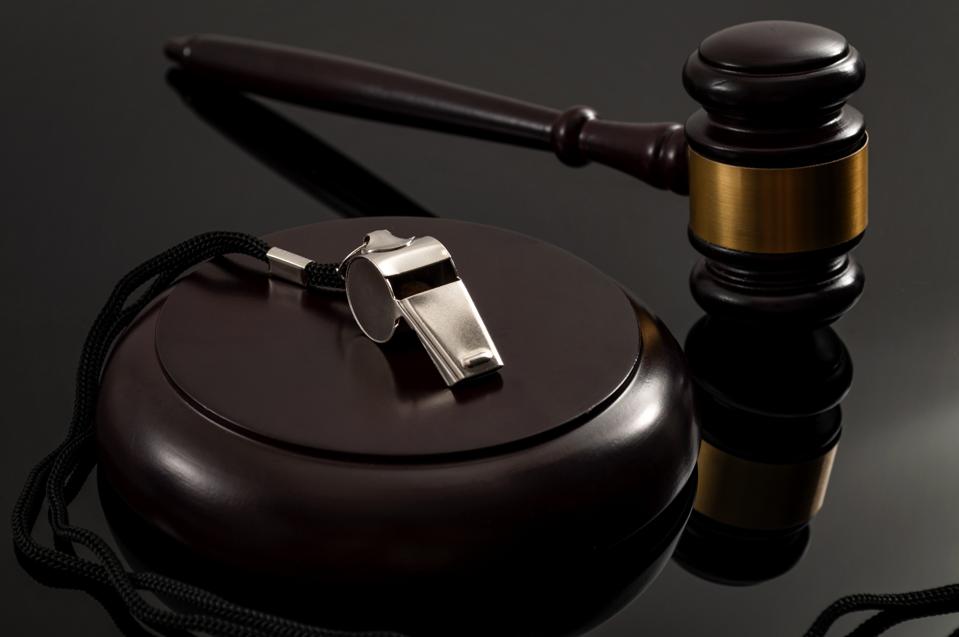 Закон про захист інформаторів і законодавство про свободу інформації концептуальна ідея з металевим свистком і дерев'яним молотком судді на темному тлі