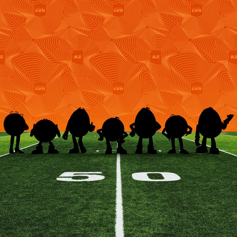 Silhouetted M&Ms on a football field.