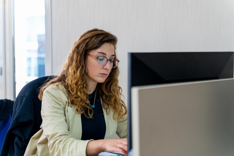 Retrato de una mujer que usa su computadora en una oficina moderna