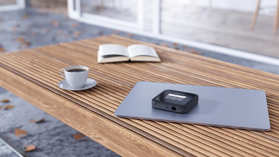 Netgear M6 Pro on a table with a coffee cup