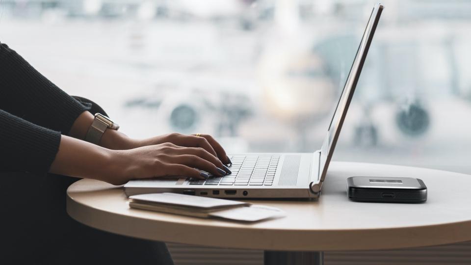Netgear M6 Pro and a person using a laptop