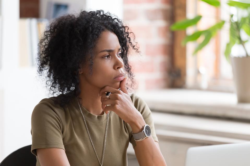 Una mujer de negocios o estudiante afroamericana pensativa que se siente insegura