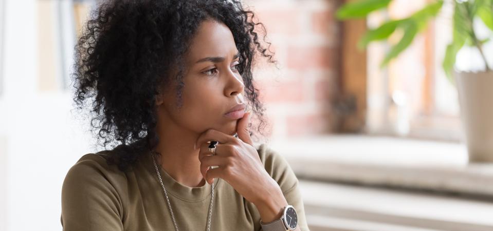 Una mujer de negocios o estudiante afroamericana pensativa que se siente insegura