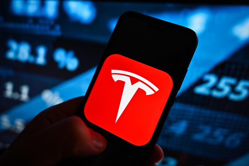 En esta ilustración fotográfica, se muestra un logotipo de Tesla en un...