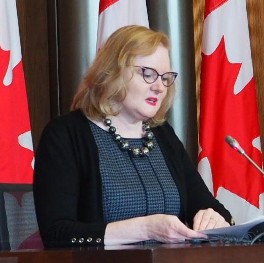 Margaret Eaton habla en un podio en una conferencia de prensa.