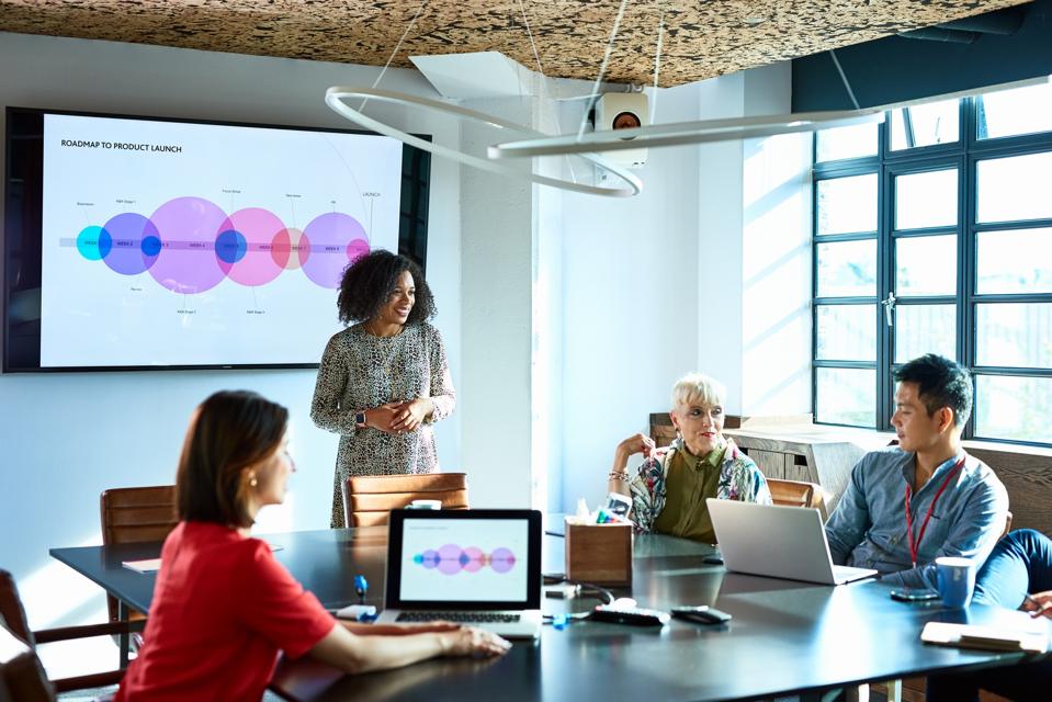 Atractiva mujer de negocios encabeza una reunión de estrategia en la sala de juntas