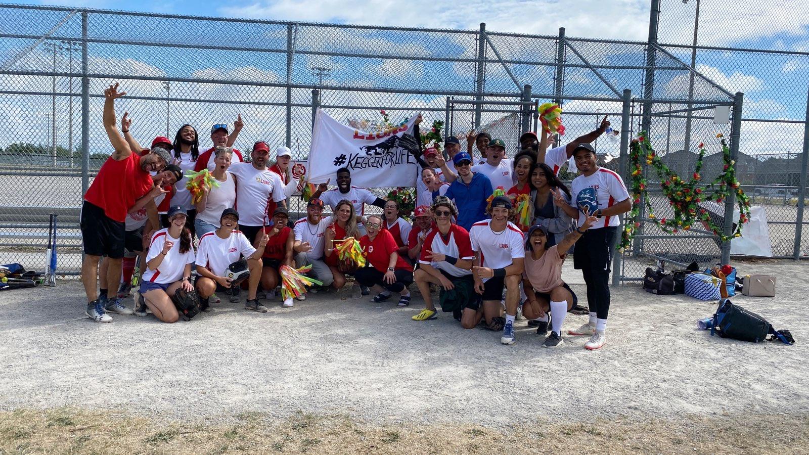 El personal posa para una foto de celebración en un partido de béisbol.