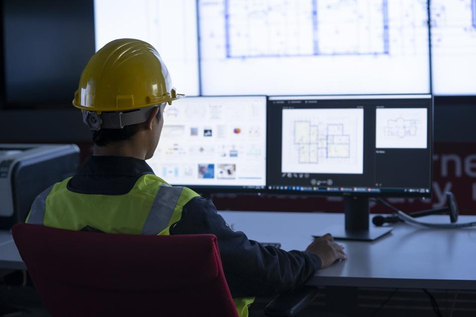 Ingeniería Industrial trabaja frente a una pantalla de monitoreo en el centro de control. tecnología y concepto de IA.