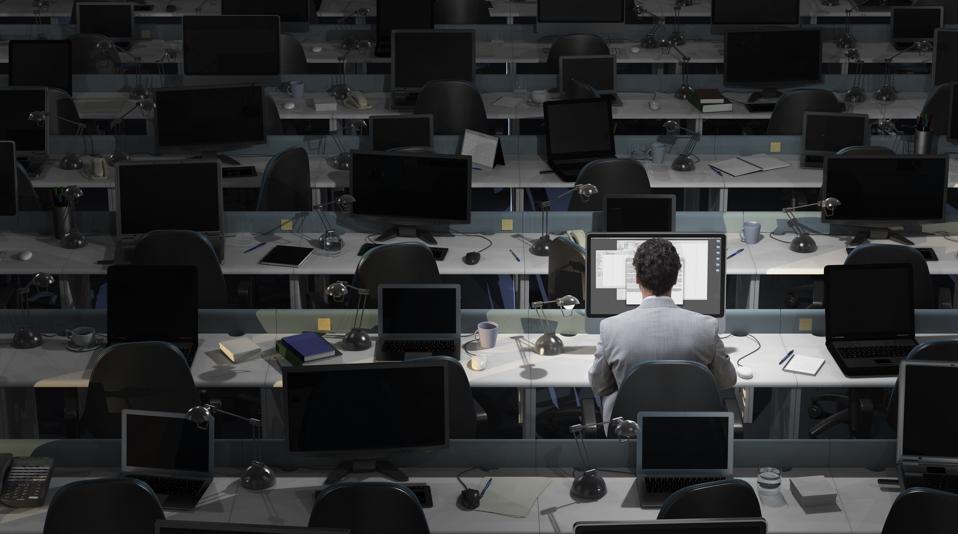 Un oficinista se sienta a trabajar en una oficina vacía