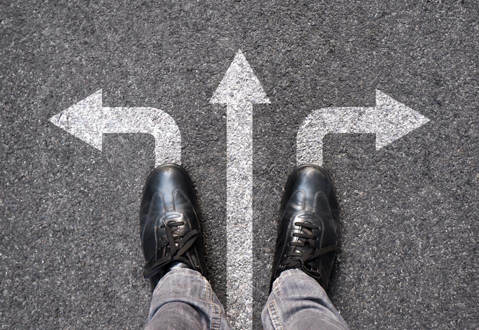 Pies y flechas en el fondo del camino. Selfie pies arriba. Empresario de pie en el camino con la elección de tres flechas de dirección o avanzar. Vista superior de zapatos de negocios caminando. Motivación y crecimiento.
