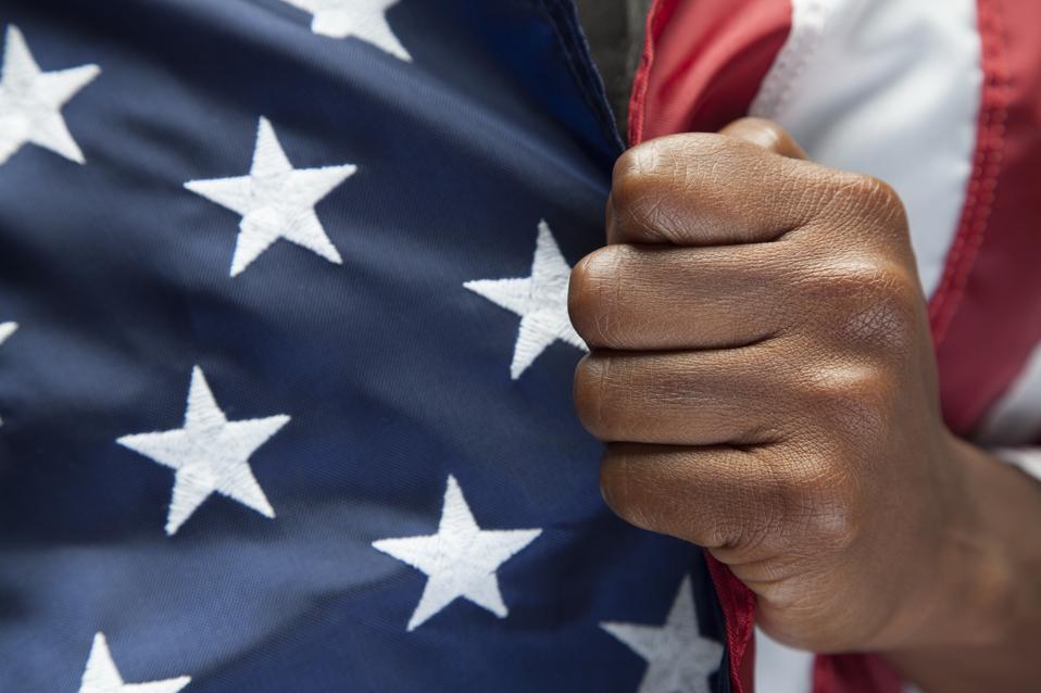 Black hand gripping American flag