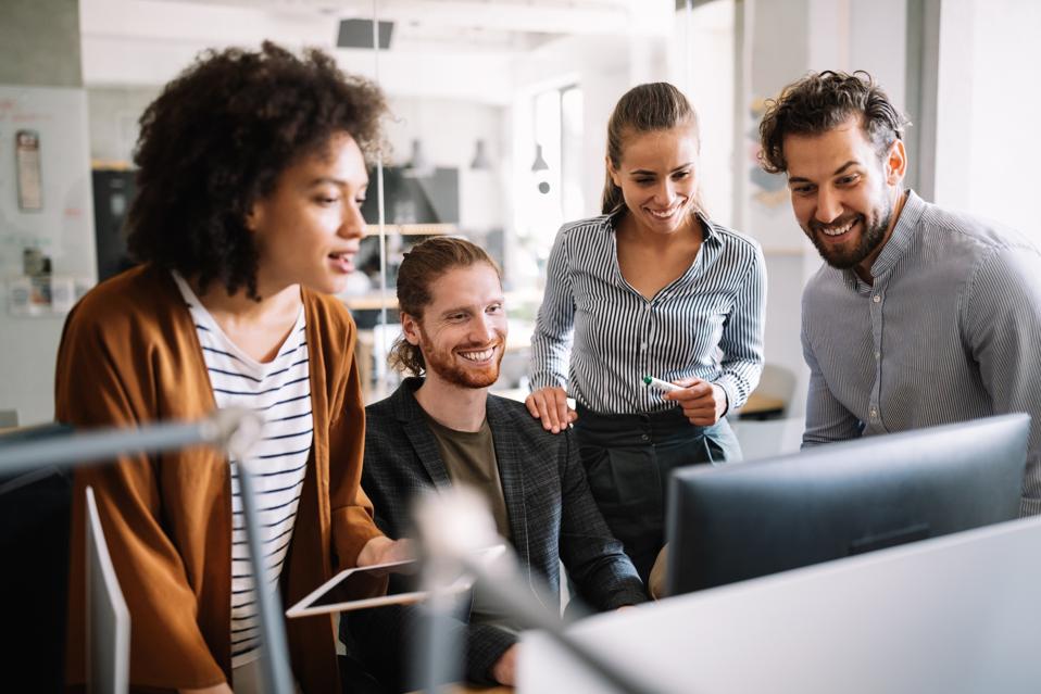 Team meeting at the office in front of a desktop computer.