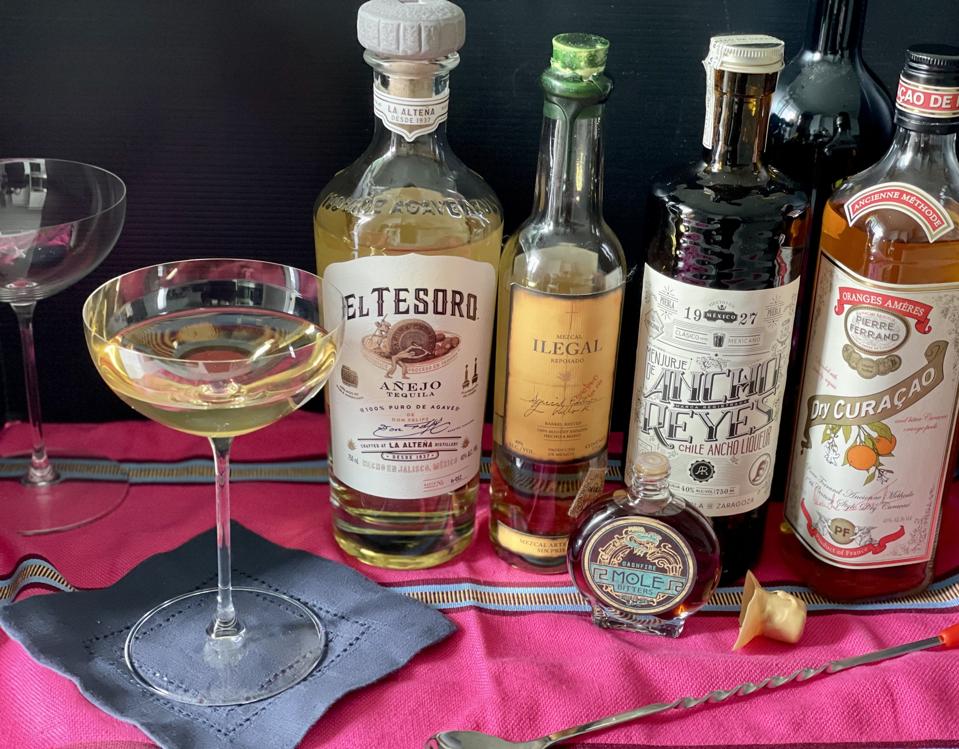 The Frida is made by combining and balancing five spirits and a dash of bitters. Pictured in the photograph by Elizabeth Karmel are El Tesoro Anejo, Illegal Reposado Mezcal, Chile ancho Reyes, Dry Curaco Absinthe and Dashfire Mole bitters.