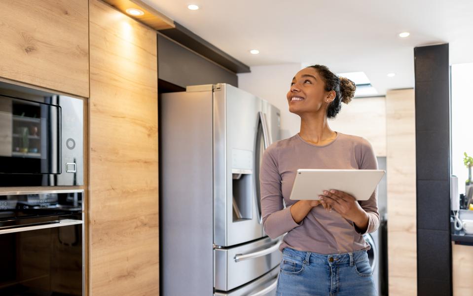 Woman controlling the lights of her smart house using an automated system