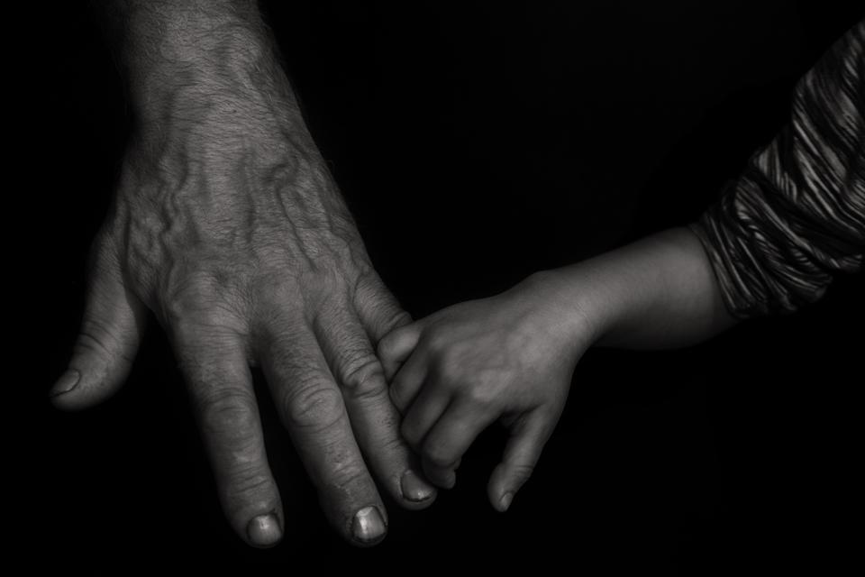 Grandson holding his grandfather's hand