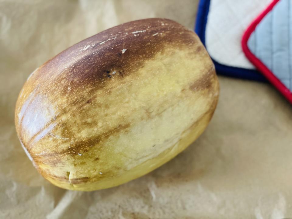 In this photograph by Elizabeth Karmel is a lightly browned roasted whole Spaghetti squash. Whole roasted winter squash should retain it's shape and the  exterior skin should be nicely browned in places.