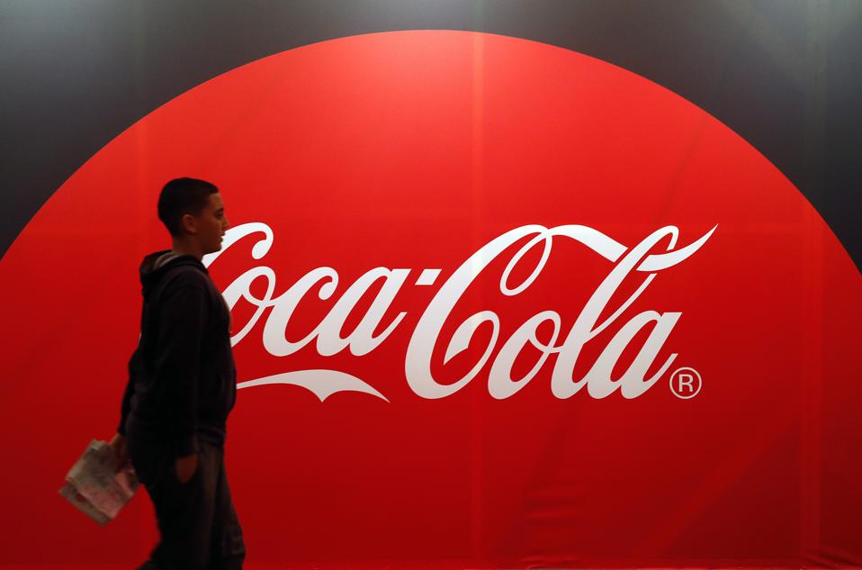 Coca-Cola billboard with human walking passed it