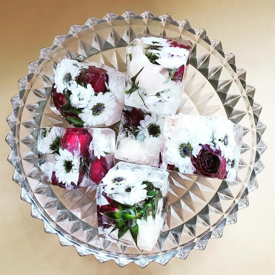 a tray of ice cubes embedded with fresh flowers