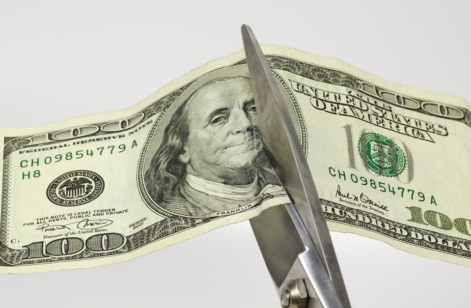 Symbolic photo of scissors cutting a hundred dollar bill