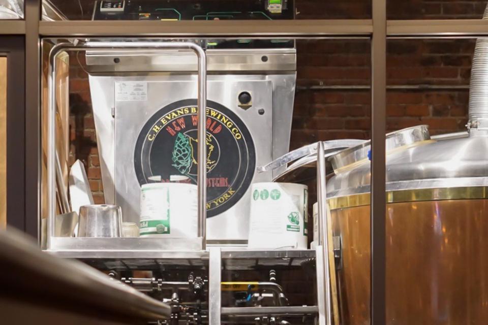 Brewing equipment and Hanks viewed from viewed through a clear window inside of an industrial brewery