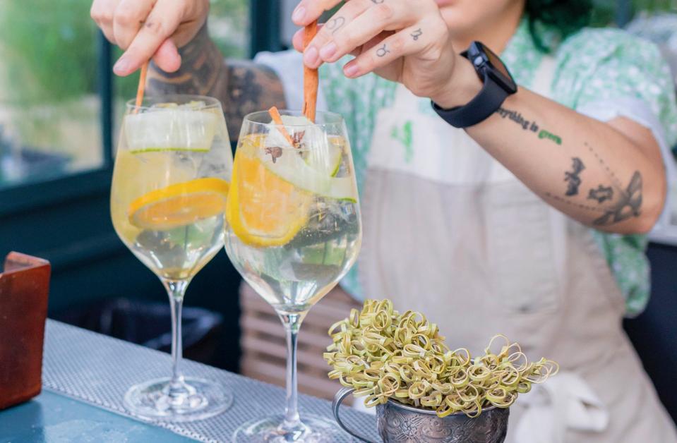 A bartender mixing two cocktails