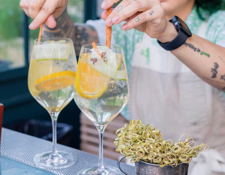 A bartender mixing two cocktails