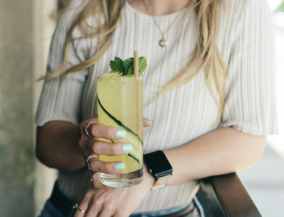 Woman holding a cucumber cocktail