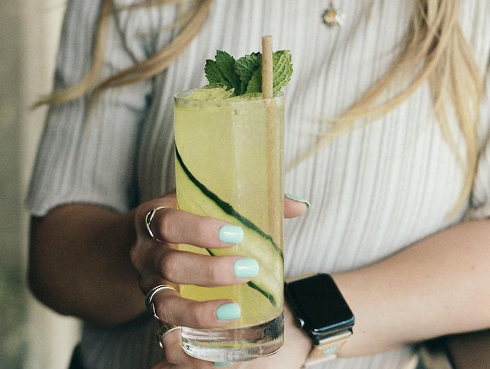 Woman holding a cucumber cocktail
