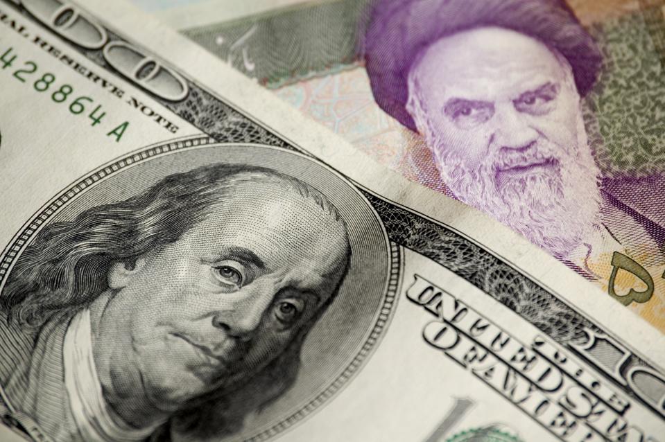 An American $100 bill and an Iranian 50,000 rial note