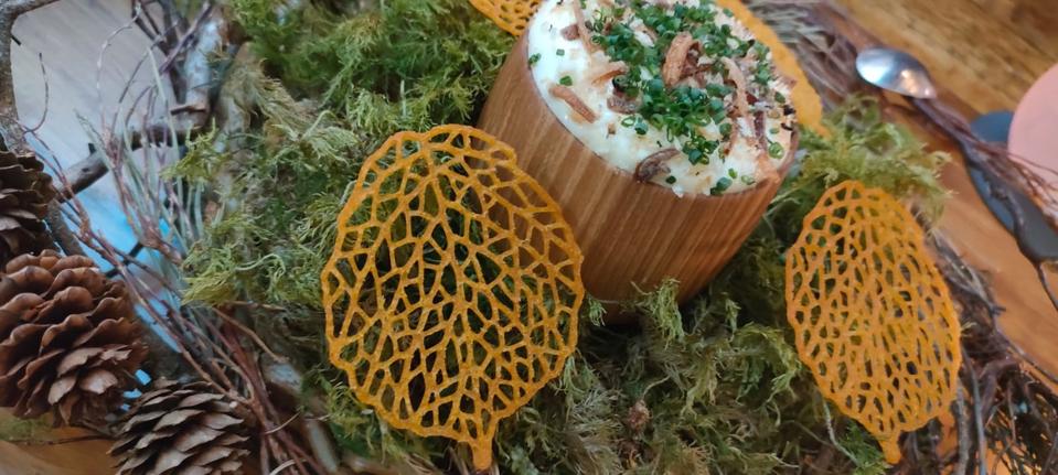 a dip of whipped Isle of Mull cheddar accompanied by leaf-shaped sweet potato crisps, served in a nest plate surrounded by Scottish moss. 