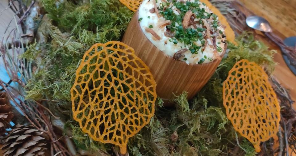 a dip of whipped Isle of Mull cheddar accompanied by leaf-shaped sweet potato crisps, served in a nest plate surrounded by Scottish moss.