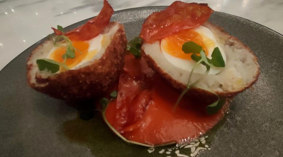 Scotch egg coated in salt cod brandade, served with red pepper purée and crispy fried chorizo.