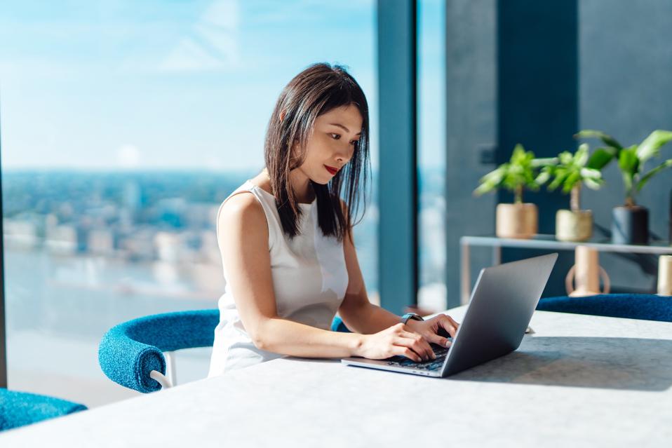 Young businesswoman working on laptop in a modern and stylish office