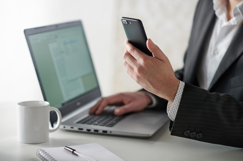 Businessman Using Smartphone And Laptop
