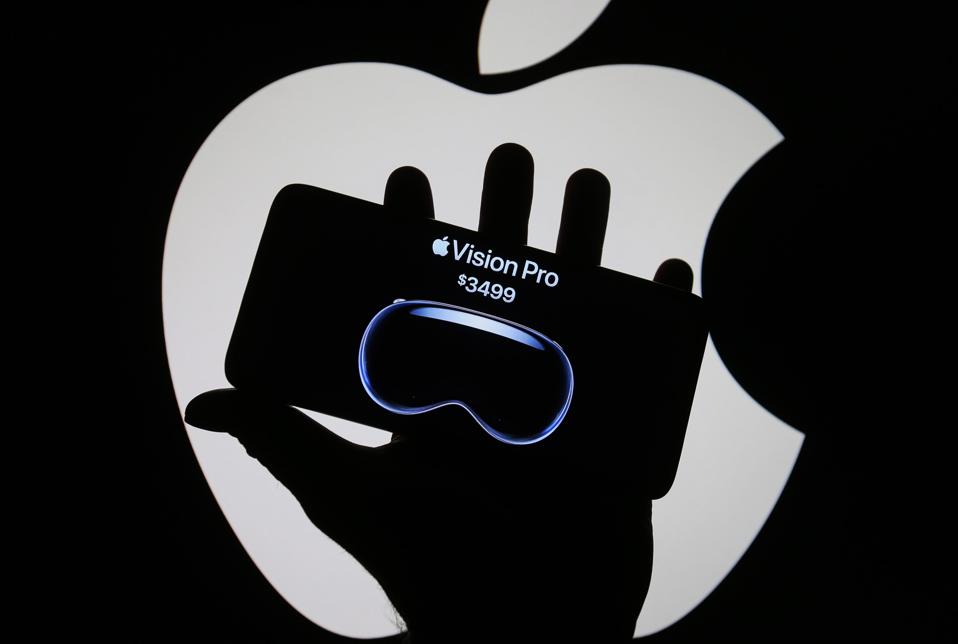 In this photo illustration, Apple Vision Pro logo and price...