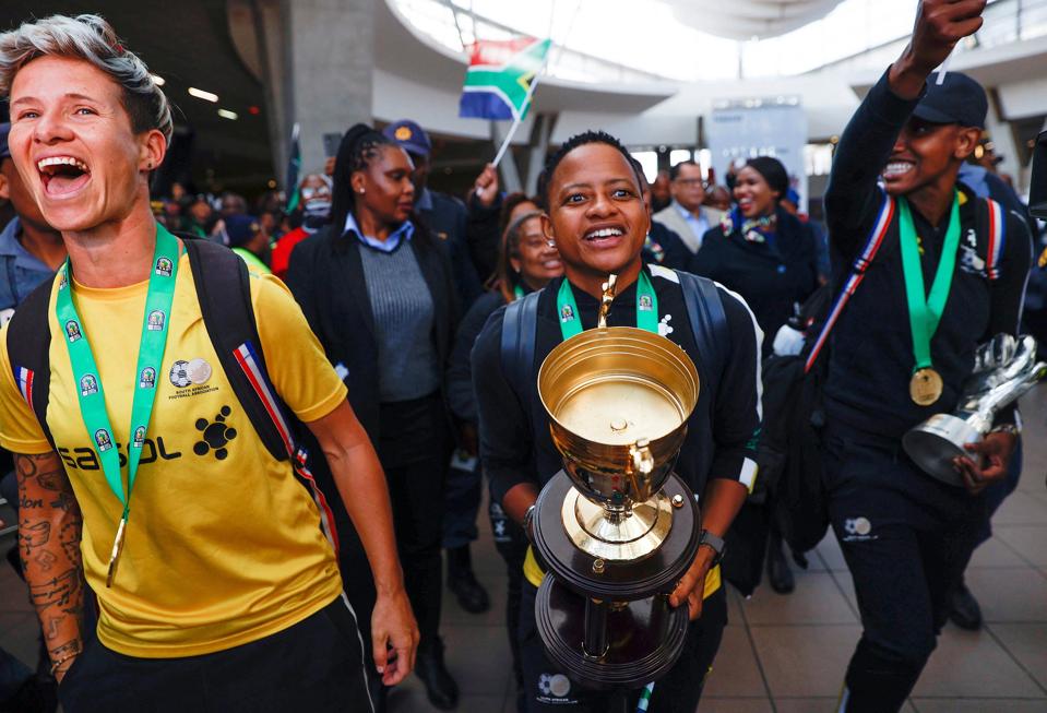 South Africans Janine van Wyk, Refiloe Jane and Andile Dlamini celebrate in the airport. 