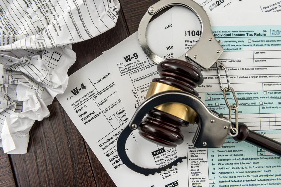 Illegal concept USA tax form with gavel and handcuff