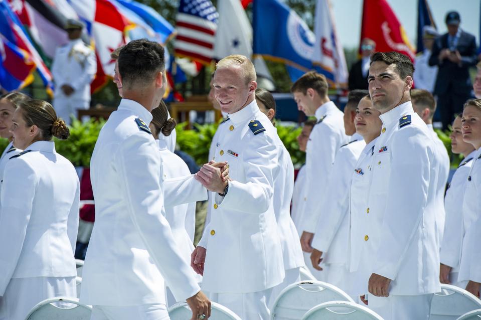 Coast Guard cadets greet each other before graduation.