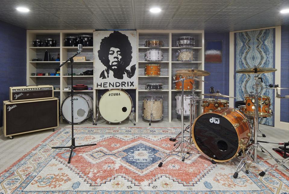 Music room with drum kits, shelving, kilim area rug and microphone.