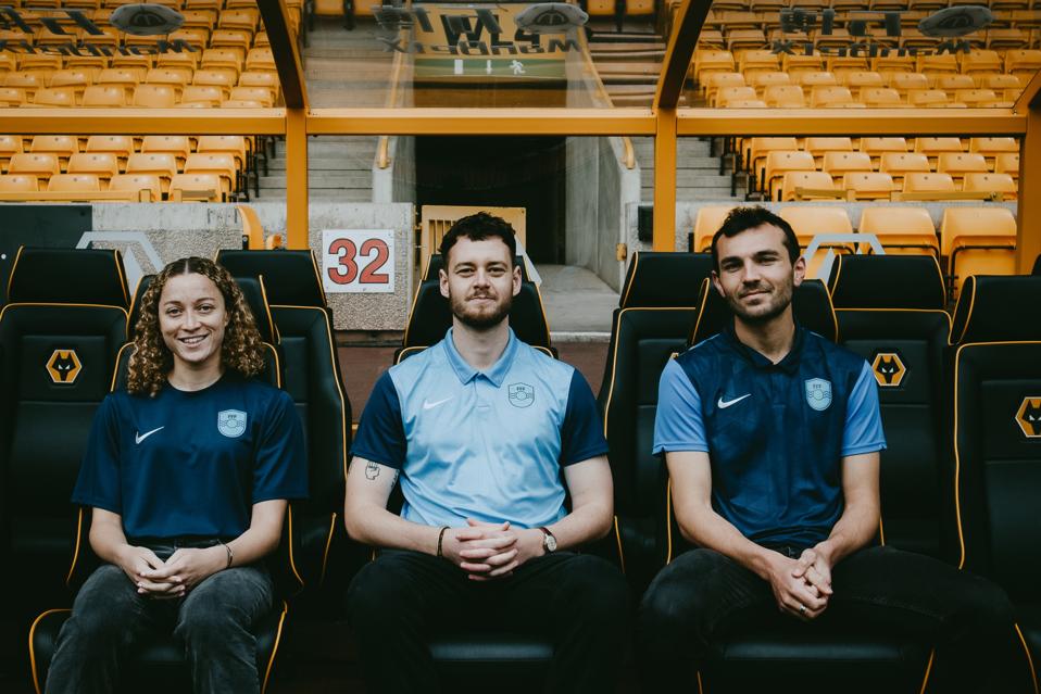 Three Football For Future staff members get their picture taken at Wolverhampton Wanderers