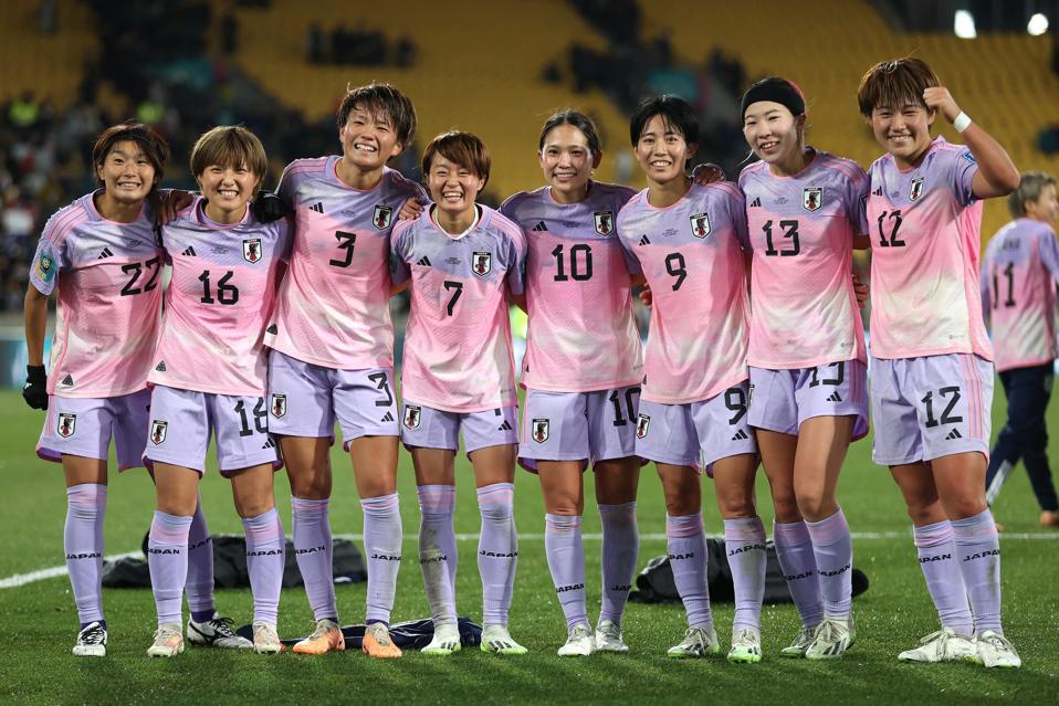 Japanese players pose for a photo on the pitch after their Round of 16 win over Norway.