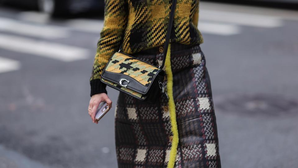 A guest seen wearing a black and yellow patterned wool pullover with a matching Coach bag outside Coach during New York Fashion Week on September 12, 2022 in New York City.
