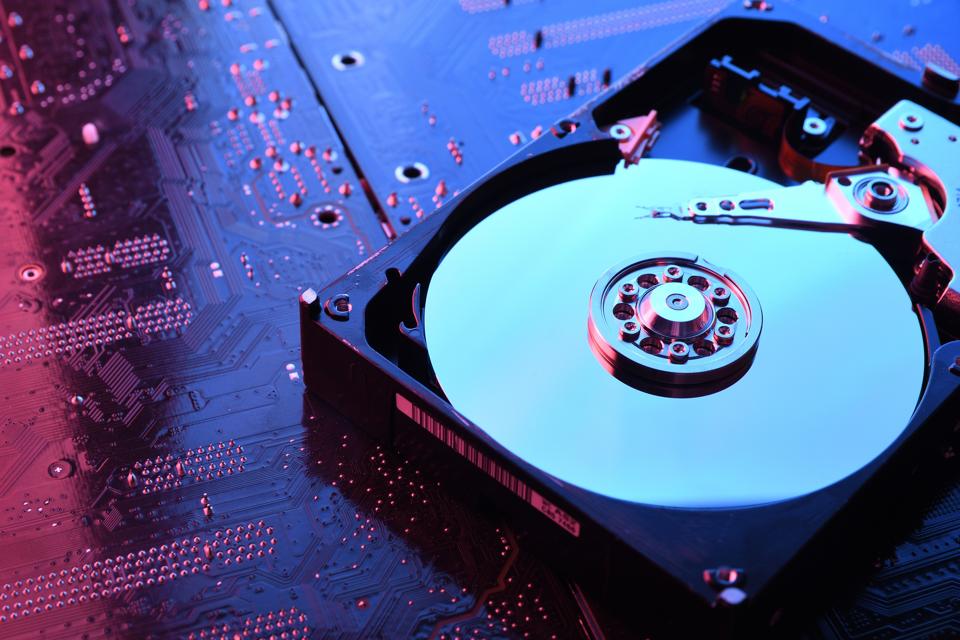 Computer Hard disk drives HDD , SSD on circuit board ,motherboard background. Close-up. With red-blue lighting
