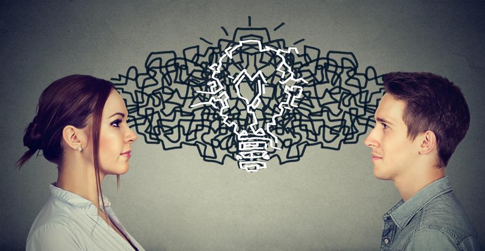 Young man and woman looking at each other exchanging their thoughts coming up together with an idea light bulb