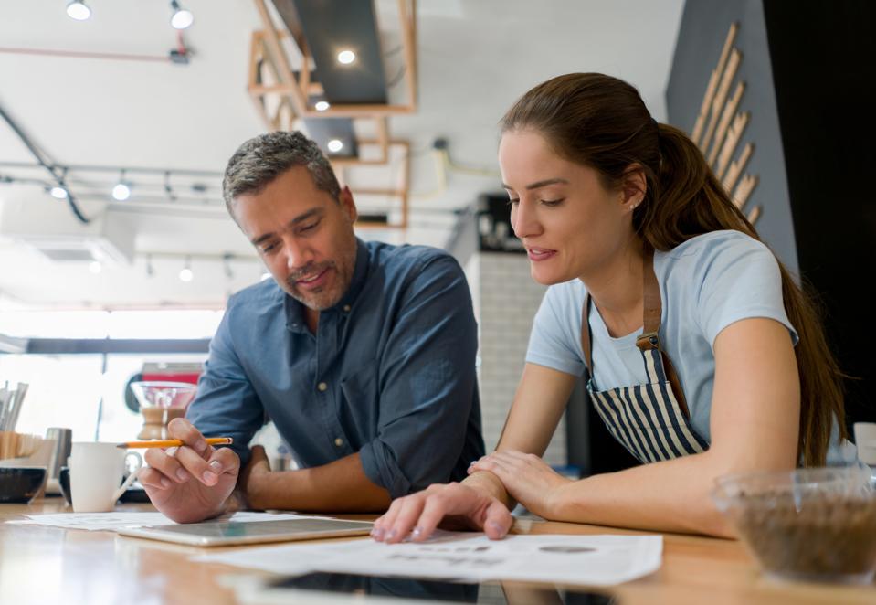 Business owners working together doing to the books at a coffee shop