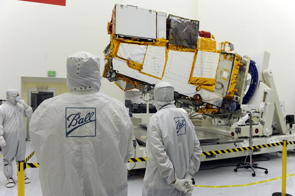 Rob Baltrum. Chief Engineer of Lead Systems at Ball Aerospace & Technologies Corp, far left, Scott Tennant, NPP Program Manager, Ball Aerospace & Technologhy, middle and Ken Hissong, Inspector for NPP check out the satellite. They are carefully dressed in