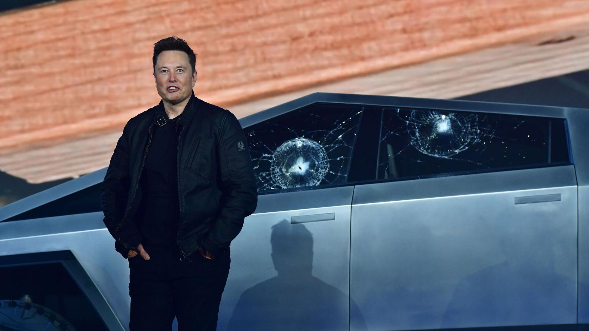 Elon Musk standing next to a Cybertruck prototype that had its windows cracked.