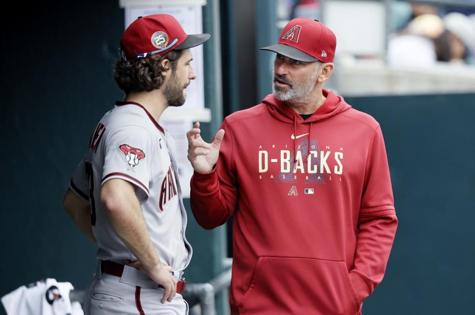 Arizona Diamondbacks manager Torey Lovullo explains a point to pitcher Zac Gallen.